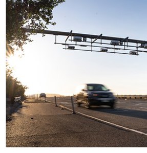 Car driving through toll gantry